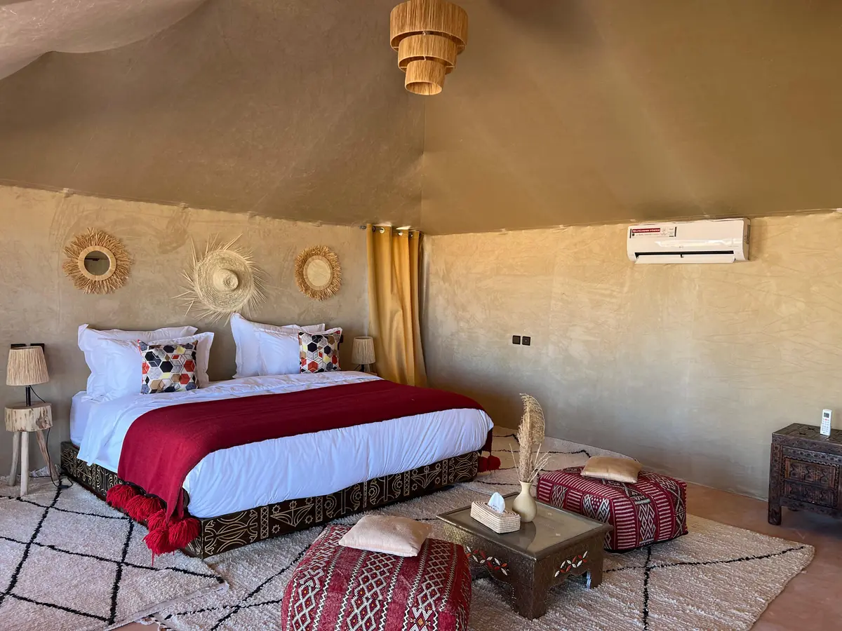 Inside a tent at the desert camp near Merzouga, with a double bed, Berber rugs and air conditioning