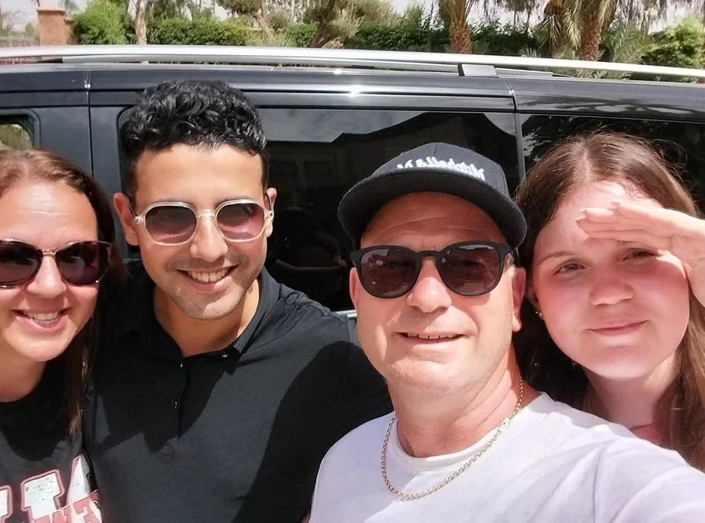 Travelers with their driver beside the van at the start of a Morocco trip