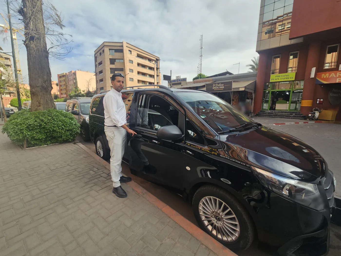 Brahim, a Morocco Classic Tours driver, beside the private Mercedes van in Marrakech
