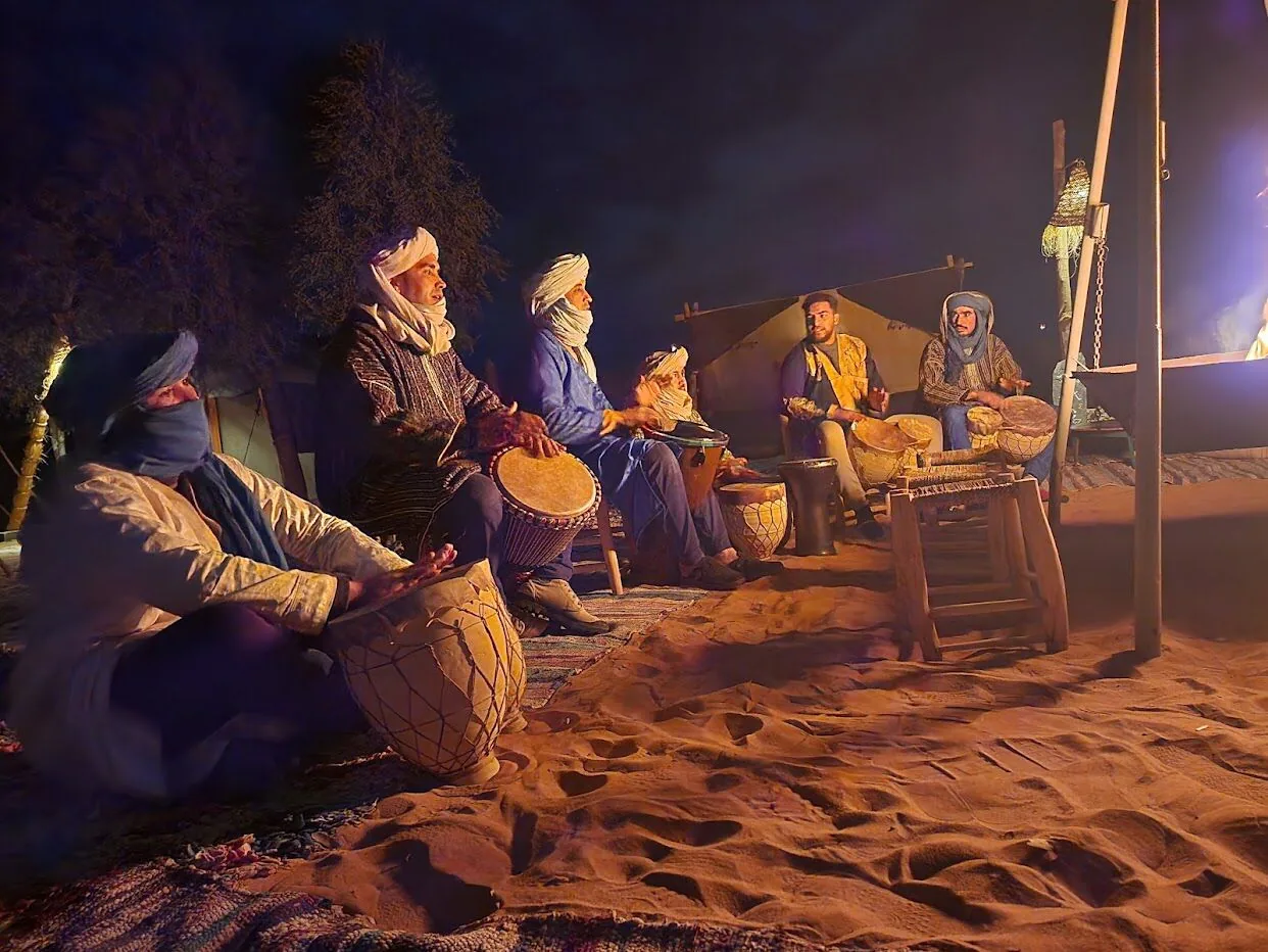 Musicians drumming at night at a desert camp near Merzouga, Morocco
