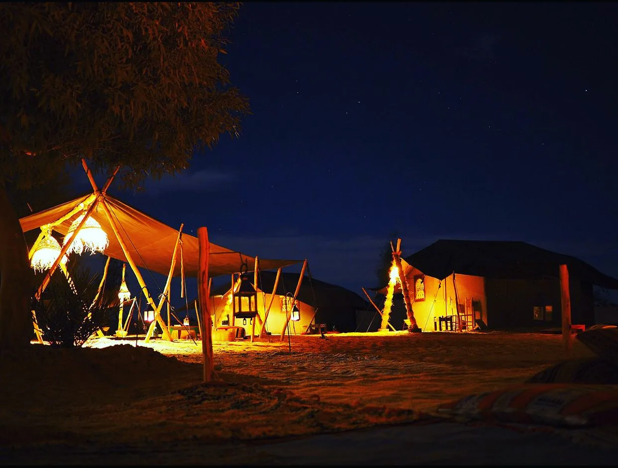 Sahara desert camp at Erg Chebbi lit up at night, Merzouga, Morocco